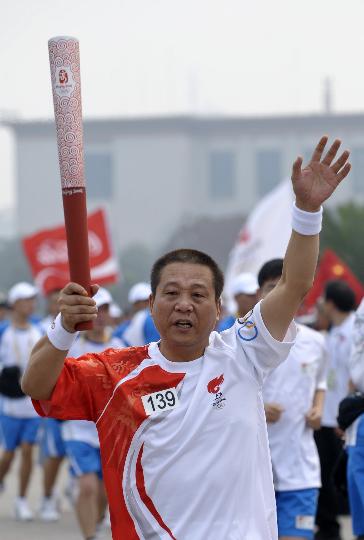 图文-奥运圣火在北京进行首日传递 印伟民招手
