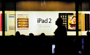 唯冠与苹果的战火越烧越烈。图为一位顾客正从IPAD的广告前走过。深圳特区报资料图片