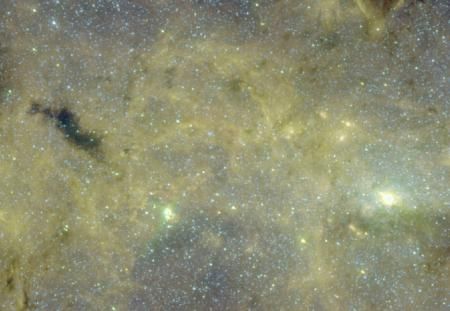 在这张照片中，美国宇航局的斯皮策空间望远镜拍摄了神秘的尘埃气体云团G0.253+0.016(即图像中左侧暗色区域)。图像右侧明亮区域为银河中心