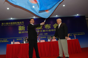 钱永昌（右）将中国物流万里行旗帜交给卢彦