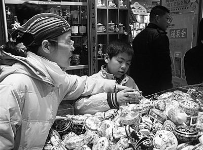 在北京王府井大街一家专营旅游纪念品的店里,顾客正在挑选10元一个的景泰蓝小首饰盒。本报记者陈莹莹摄 在北京王府井大街一家专营旅游纪念品的店里,顾客正在挑选10元一个的景泰蓝小首饰盒。本报记者陈莹莹摄