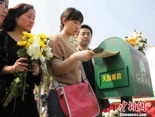 前来祭祀的群众向逝者投递通往天堂的信件 鄢银婵 摄 前来祭祀的群众向逝者投递通往天堂的信件 鄢银婵 摄