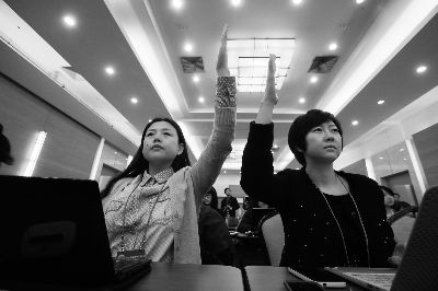 大图为本报记者白冰（左）和陈斯在现场不约而同举手提问 摄/法制晚报记者 付丁刘畅