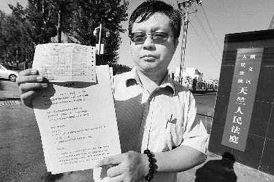 林峰在法院門前向記者出示起訴書和行程單