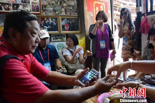 图为海外华文媒体代表品尝特色小吃、茶水。 张金川 摄 图为海外华文媒体代表品尝特色小吃、茶水。 张金川 摄