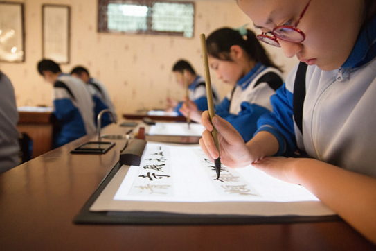 学生们使用华文众合智云数字书法临摹台练习书法 华文众合智云数字书法将亮相2017全国双创活动周