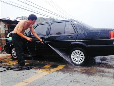 前日，昌平区立水桥附近，一洗车店工人正在用地下水洗车。新京报记者 李宁 摄