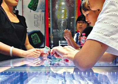 王府井步行街“异域风情珠宝”店，工作人员手持奖券告诉“抽奖”的顾客，“中了一等奖”。