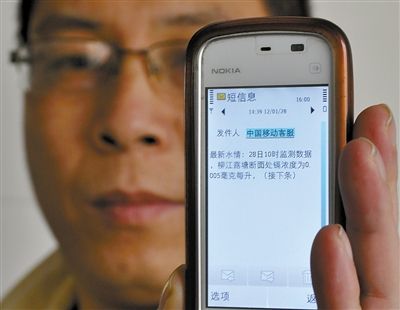28日,广西柳州,一男子展示刚刚收到的水质监测情况短信。新华社记者 陆波岸 摄 广西柳州启动地下水源“保卫柳江”