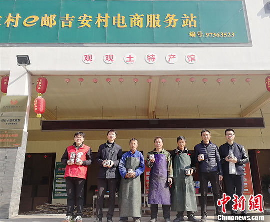 2017年12月7日,几名农民电商代表站在江西上饶县应家乡吉安村电商服务站前。 中新社记者 苏路程 摄 互联网开启无界沟通 铺就江西农民脱贫路