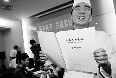 来自湖南长沙的厨师杨文李高兴地拿到了续签的