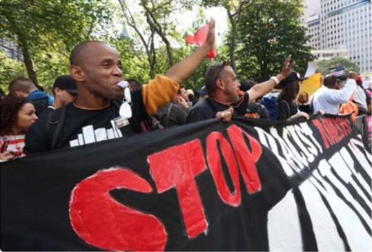 美国黑人拉着条幅抗议种族歧视