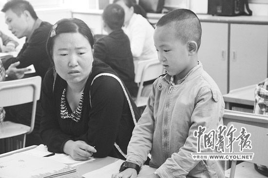  斌斌在课堂上，妈妈王文丽在陪读。