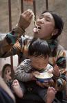 图文：藏族女子咬断方便面喂小孩