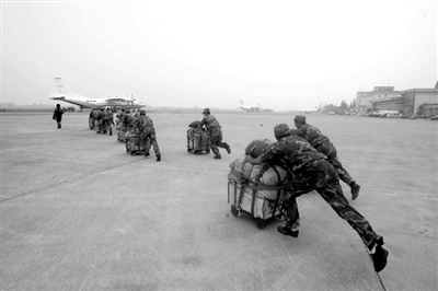 在成都太平寺机场,空降部队官兵快速将赈灾物资运送到飞机上.