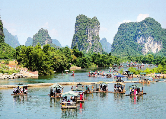 游客在桂林阳朔县遇龙河景区乘竹排游玩