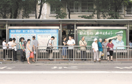 9月22日,同仁路口公交站台,市民站在不锈钢护栏后等车 陈蒙川 摄