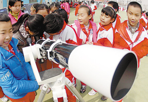 图为济南市营东小学的学生们通过天文望远镜观
