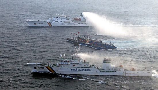 韩国海警向捆绑在一起的中国渔船发射水炮。资料图片