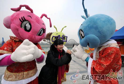 图片说明:欢乐谷的吉祥物"欢欢"乐乐"和"谷谷"身着唐装,向游客拱手