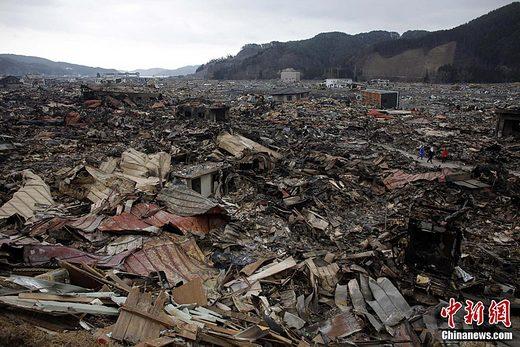 3月15日，日本9.0级大地震和海啸过去后。日本岩手县的一个小镇变成了一片瓦砾，人们在这片地区搜索被困人员和能够使用的物品。