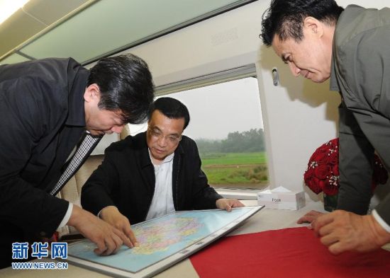 3月30日至4月2日，在出席博鳌亚洲论坛2012年年会期间，中共中央政治局常委、国务院副总理李克强来到海口、澄迈、琼海等地进行考察调研。这是3月31日，李克强乘高铁自海口至博鳌途中，听取海南国际旅游岛铁路和交通建设情况汇报。 新华社记者 饶爱民 摄 