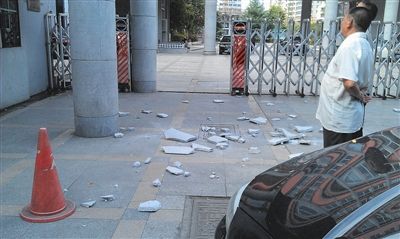 小学门口水泥柱掉石板砸坏一辆宝马车引擎盖