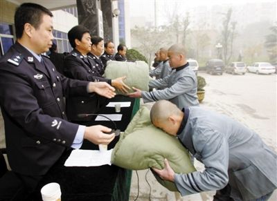 2006年11月22日，西安，20名劳教人员从劳教所民警手中接过赠送的过冬棉被棉衣。资料图片