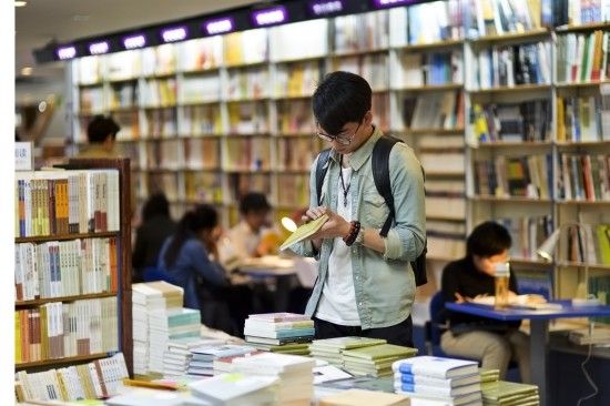 4月9日凌晨，一名读者在三联韬奋书店挑选图书。 新华社发