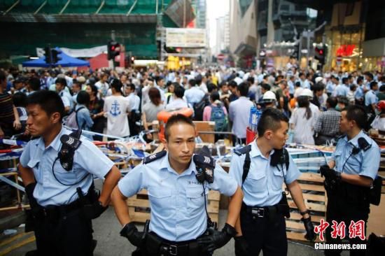 10月23日下午，香港“占领中环”非法集会者在旺角阻挡市民清除路障，引起混乱，警察在现场维持秩序。“占领中环”非法集会已进入第26日，香港市民已愤怒不已。中新社发 盛佳鹏 摄  