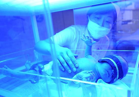 图文:护士在给刚出生10多天的婴儿照蓝光