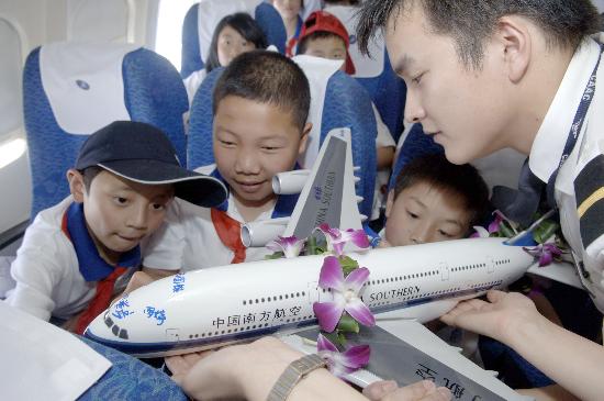 图文:四川地震灾区儿童在飞机模型上签名