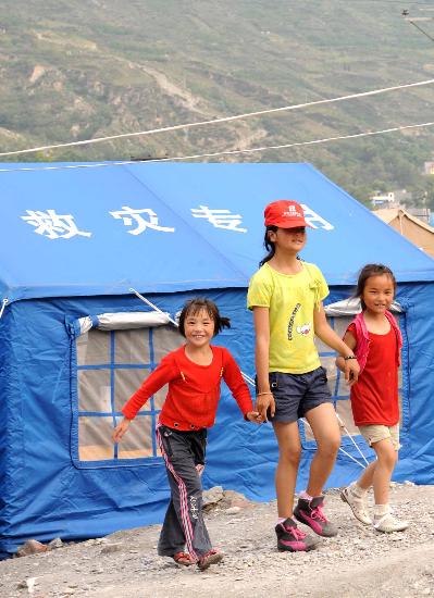 图文:阿坝州儿童福利院的孩子走在帐篷营地前