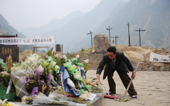 图文:何先通在地震遗址公园祭坛边打扫卫生