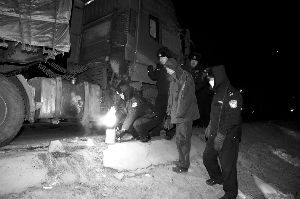 30日凌晨，疏导民警帮助司乘人员烘烤被冻结的油箱。