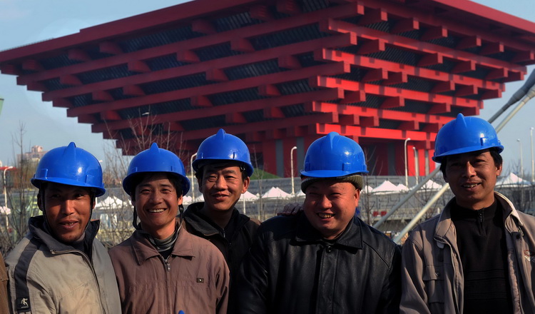 图文:五名工人以中国馆为背景留下合影
