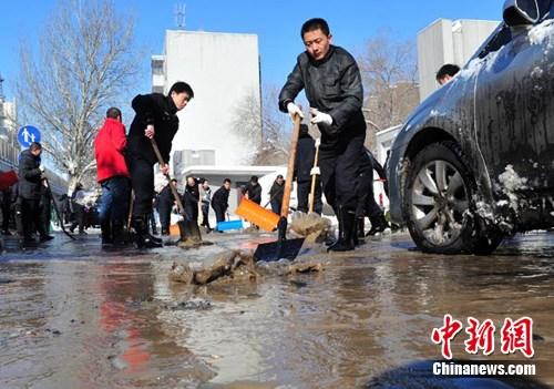 图为乌鲁木齐市区一处水管发生爆裂，路面有许多积水。