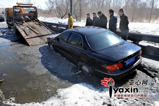 新疆乌鲁木齐市三车先后顺次掉进路面水坑(图)