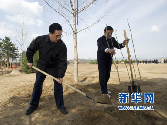这是胡锦涛同大家一起植树。 新华社记者李学仁摄