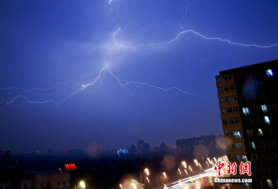 的北京城终于降下雨点,半小时后雨量加大并伴随大风,随后开始电闪雷鸣