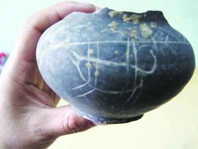 墓葬出土的带有早期文字符号的黑陶罐。