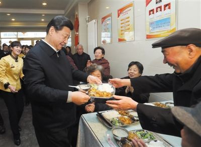 2013年2月4日，兰州一家“虚拟养老院”的养老餐厅，习近平端起一个盛满饭菜的餐盘，走到72岁的老人杨林太面前，轻轻送上，请他用餐。新华社记者 兰红光 摄