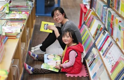 昨晚10时，来京探亲的山东的李女士带着5岁的女儿琪琪在三联书店读书。4月18日晚开始，三联韬奋书店正式开启“不打烊书店”。新京报记者 陈杰 摄