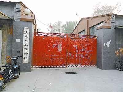 兴华学校的红色大门，油漆剥落，锈迹斑斑。