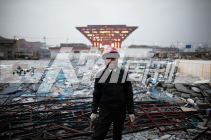 2010年1月7日，上海世博会中国馆前，主体工程完工后，工人站在拆除的工棚宿舍废墟。中国经济的辉煌，离不开底层的透支与付出(方迎忠)