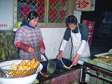 王强夫妇在炸油条.