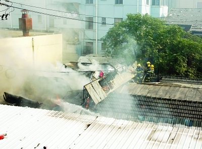铁皮棚仓库失火烧塌两间房顶货主欲闯火场“救”货物被民警拉住