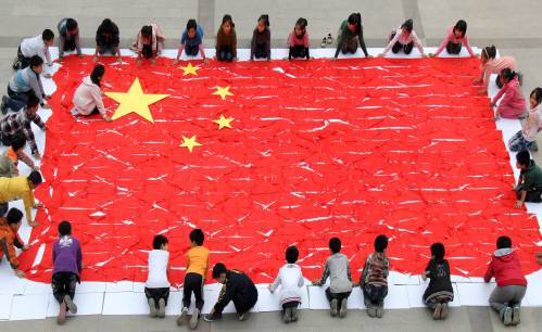 日,河南省温县第一实验小学的少先队员用红领巾和五角星拼出五星红旗