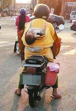 老妇骑车背巾没绑紧 差点掉孙子(图)