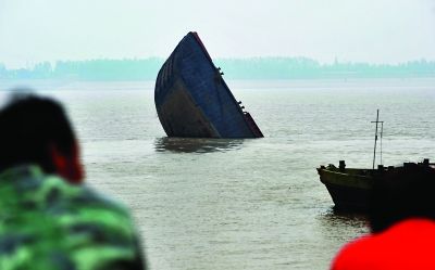 船尾部分沉入江中，船头部分露出江面。记者李子云 摄
